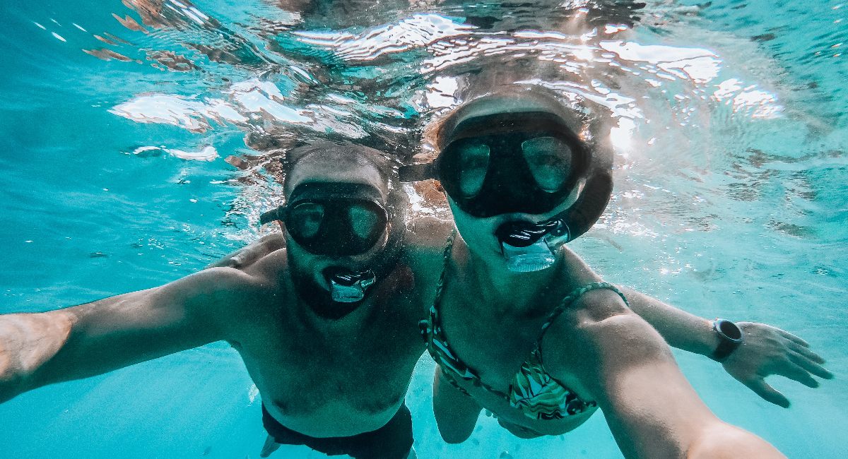 A man and a woman taking a selfie while snorkeling in Kāʻanapali