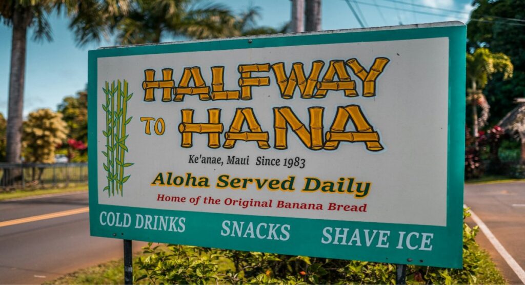 Halfway to Hana roadside stand sign advertising original banana bread, cold drinks, and shave ice 