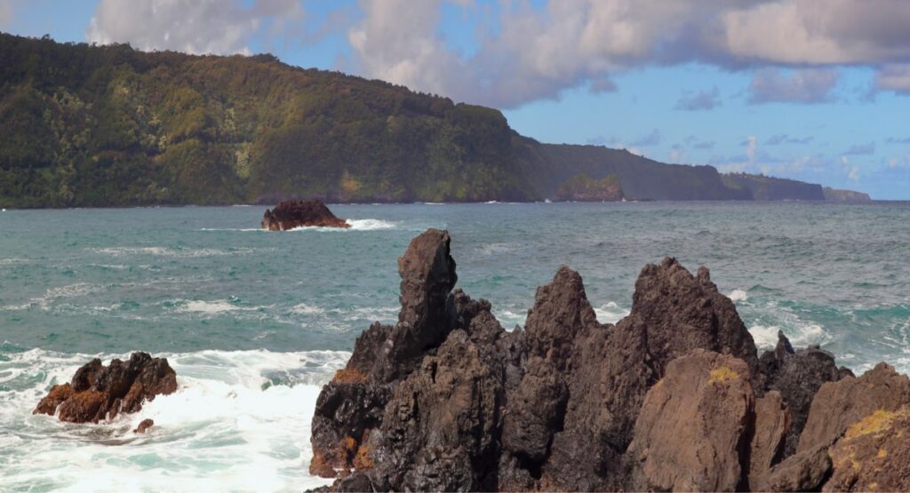 A rocky beach with a hill in the background at Ke‘anae Peninsula