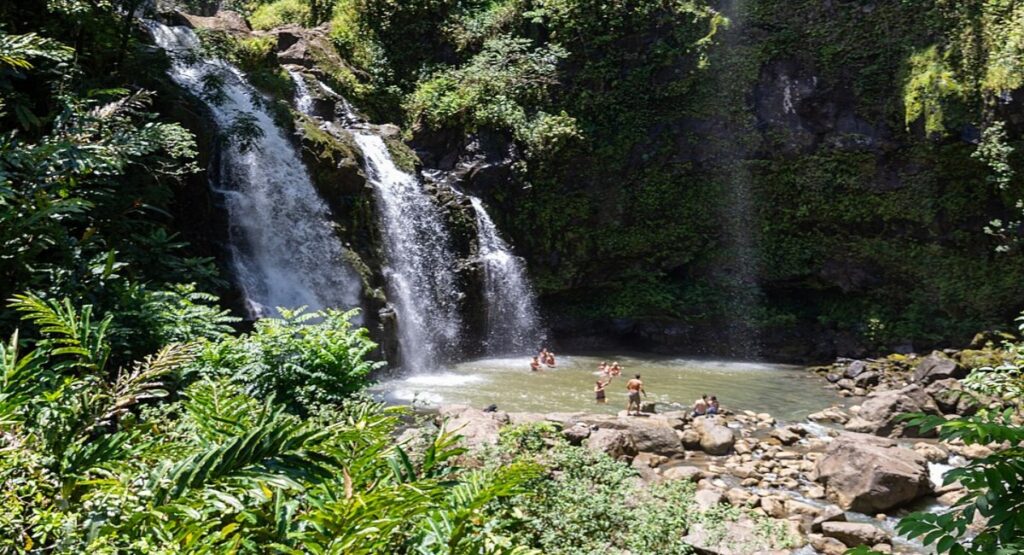 Upper Waikani Falls cascading over moss-covered rocks into a swimming hole 